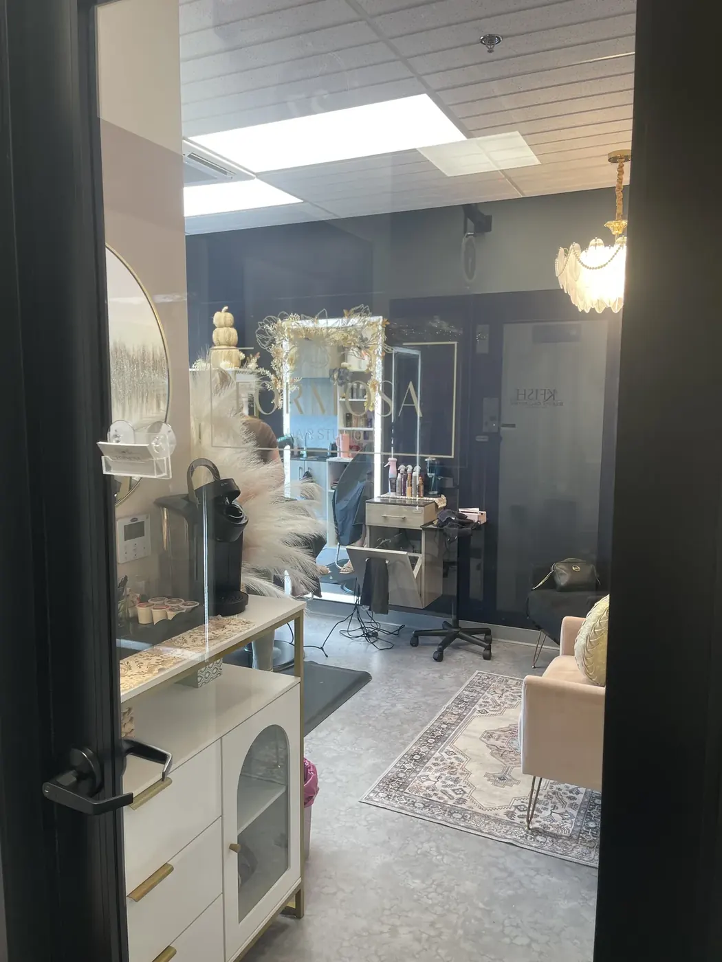 Inside Formosa Hair Studio in Erie, PA — the private styling suite with coffee station, gold framed mirror and styling chair